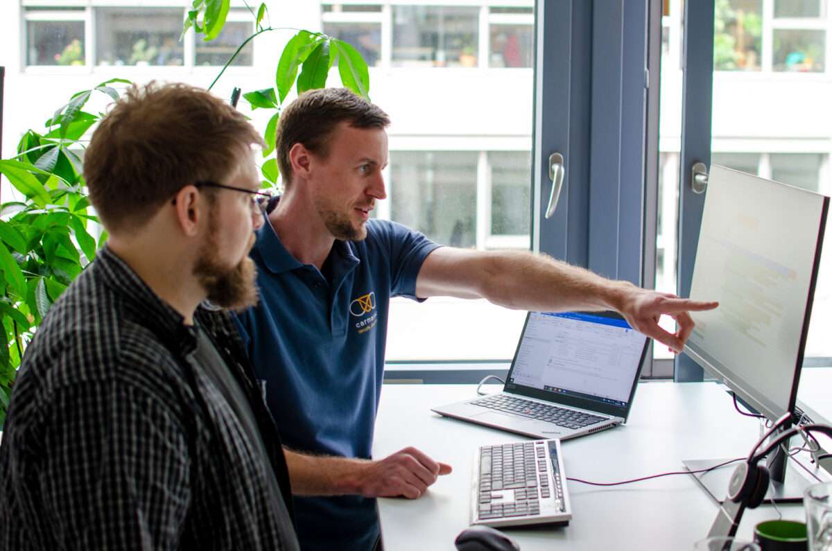 Jan Sudmeyer, Geschäftsführer der carmasec, erläutert Security Consultant Simon Decker einen Projektplan
