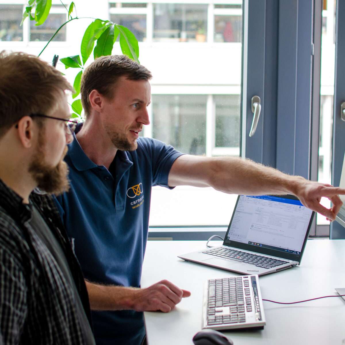 Geschäftsführer Jan Sudmeyer erläutert Security Consultant Simon Decker einen Projektplan