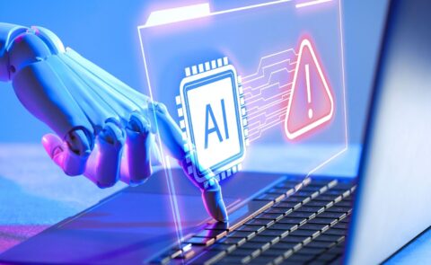Ein Roboterarm tippt auf eine Laptop-Tastatur, während ein leuchtendes AI-Symbol und ein Warnhinweis auf einem transparenten Display erscheinen.